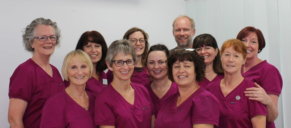 Group photo of the Old Market Dental Practice Team in pink scrubs
